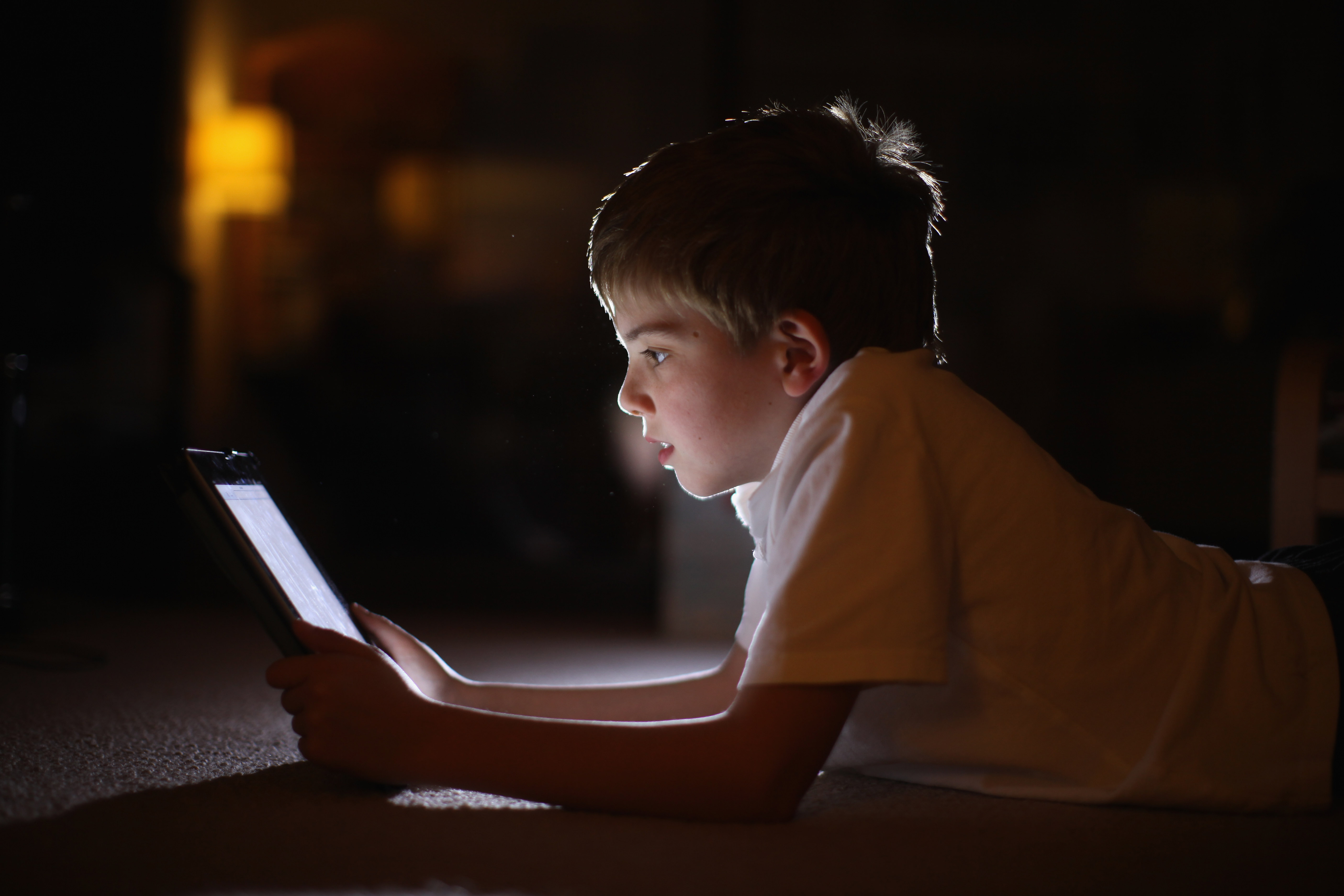 Мальчик сидит в телефоне. Ребенок за компьютером. Чтение в темноте. Мальчик с планшетом. Ребенок за компьютером в темноте.